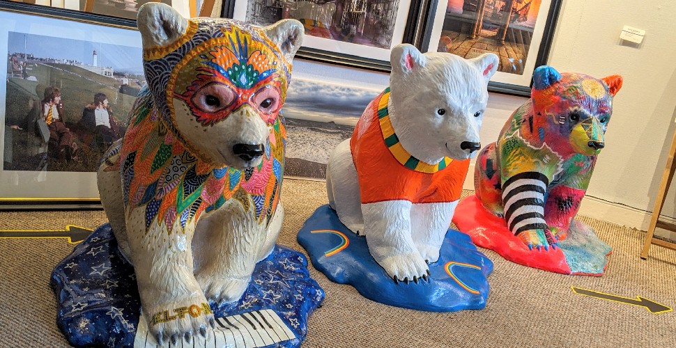 Three painted polar bear cub statues 